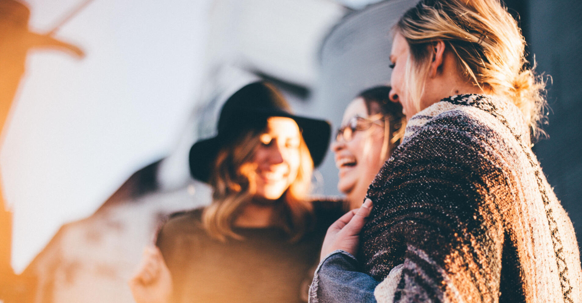 Image of people laughing, standing in the sunshine